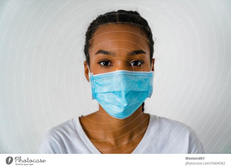 Teenage girl wearing protective face mask standing against wall during covid-19 color image colour image indoors indoor shot indoor shots interior interior view