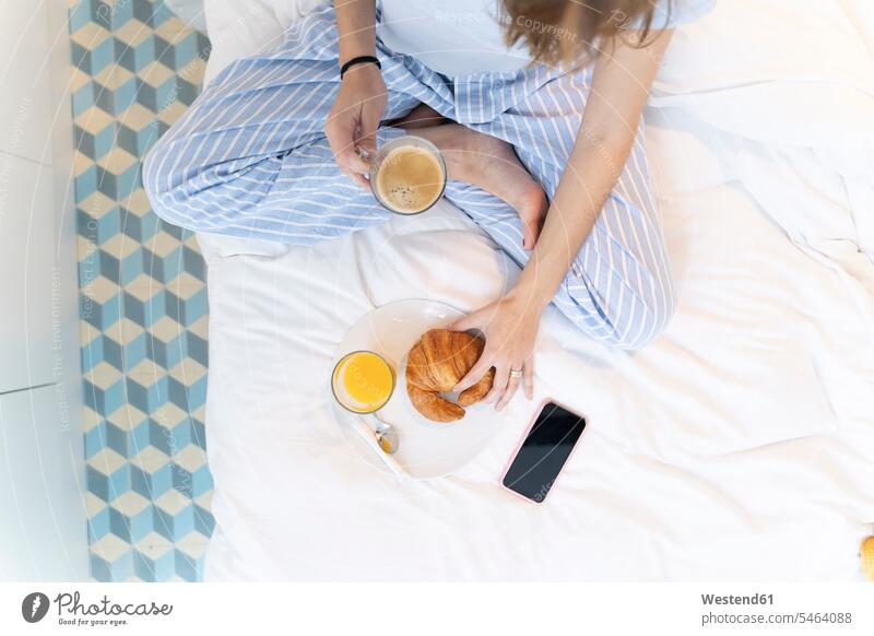 Young woman sitting on bed and having a coffee Drinking Glass Drinking Glasses Bed - Furniture beds telecommunication phones telephone telephones cell phone