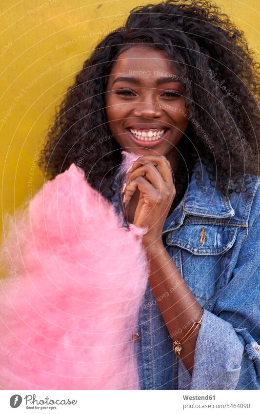 Portrait of happy young woman with pink candyfloss human human being human beings humans person persons African black black ethnicity coloured 1 one person only