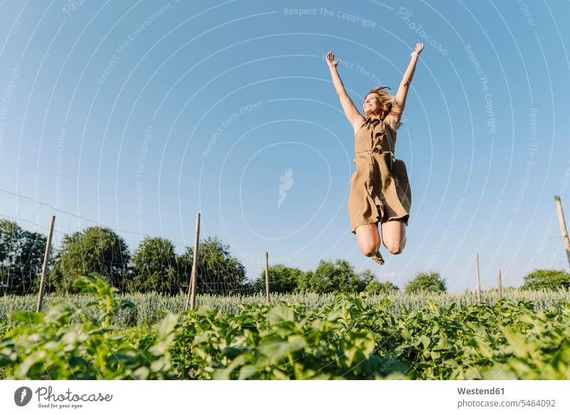 Happy young woman jumping in a vegetable patch dresses smile Ardor Ardour enthusiasm enthusiastic excited delight enjoyment Pleasant pleasure happy modesty