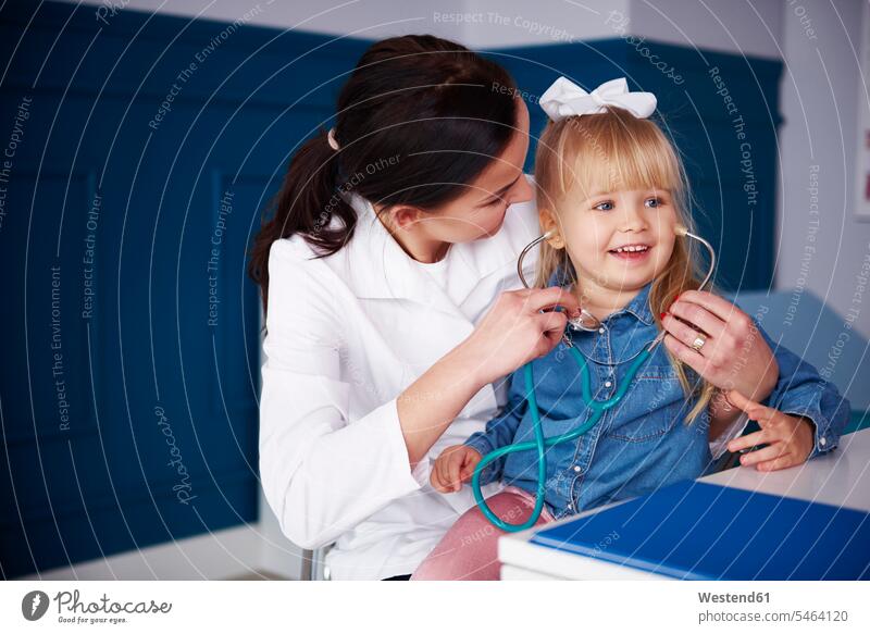 Doctor and girl playing with stethoscope in medical practice medical practices Doctors Office Doctor's Office females girls Female Doctor physicians
