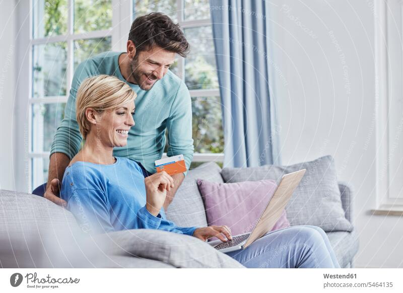 Happy couple at home shopping online twosomes partnership couples happiness happy online shopping on-line shopping people persons human being humans