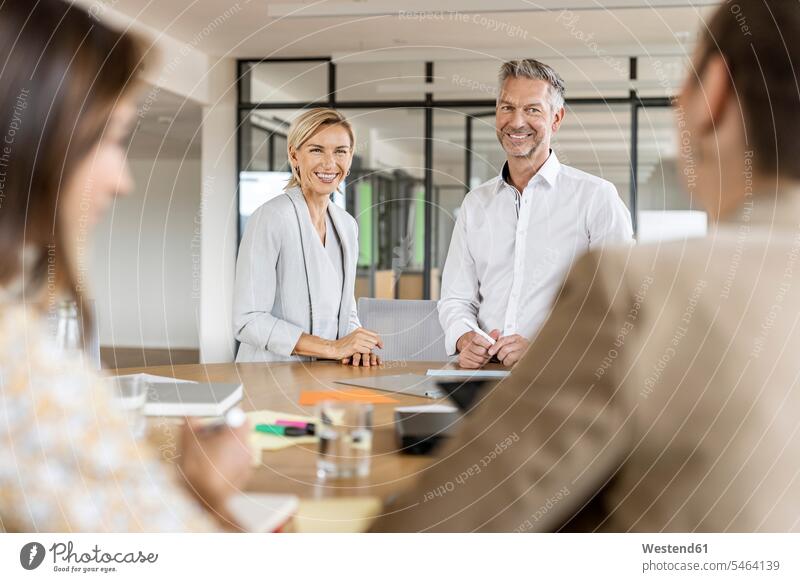 Smiling businesswoman and businessman leading a meeting in office Occupation Work job jobs profession professional occupation business life business world