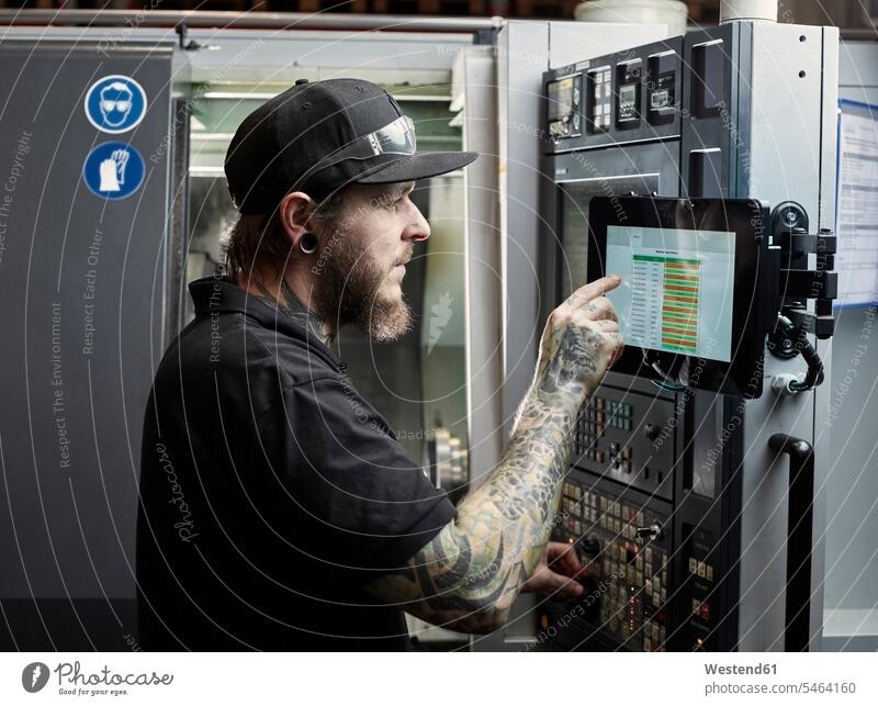 Man with tattoos working on a machine caucasian caucasian ethnicity caucasian appearance european Job Occupation Work one person 1 one person only