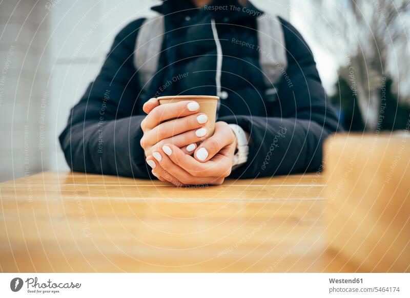 Woman drinking coffee while sitting at cafe in city color image colour image outdoors location shots outdoor shot outdoor shots day daylight shot daylight shots