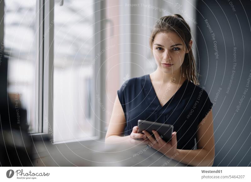 Portrait of young businesswoman with digital tablet in office human human being human beings humans person persons caucasian appearance caucasian ethnicity