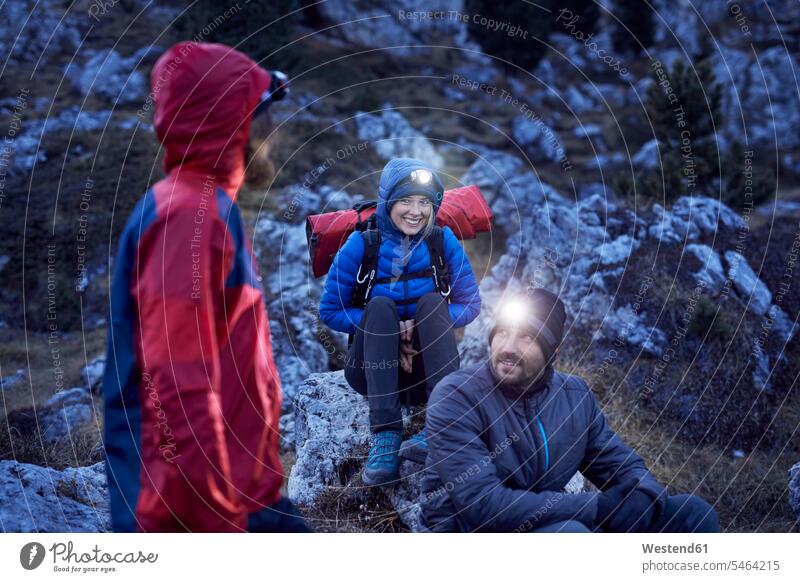 Smiling mountaineers wearing headlamps in the mountains at dusk Head Lamp Head Torch friends mate atmosphere atmospheric evening evening twilight climber