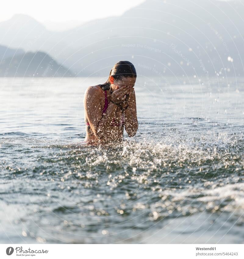 Young woman in a lake rubbing her eyes Rubbing Eyes lakes females women water waters body of water Adults grown-ups grownups adult people persons human being