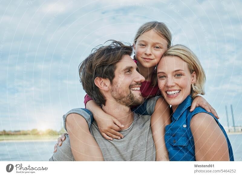 Germany, Duesseldorf, happy family with daughter at Rhine riverbank happiness riverside families Affection Affectionate daughters River Rivers water's edge