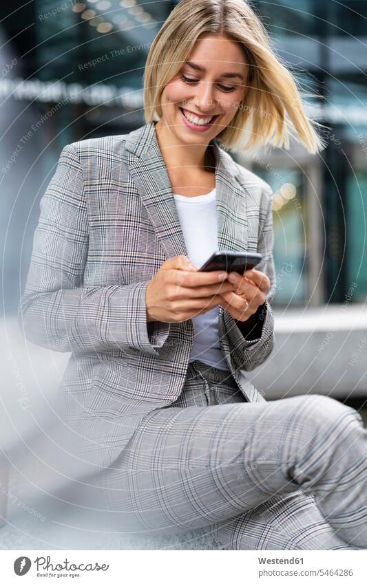 Happy young businesswoman using mobile phone in the city business life business world business person businesspeople business woman business women businesswomen