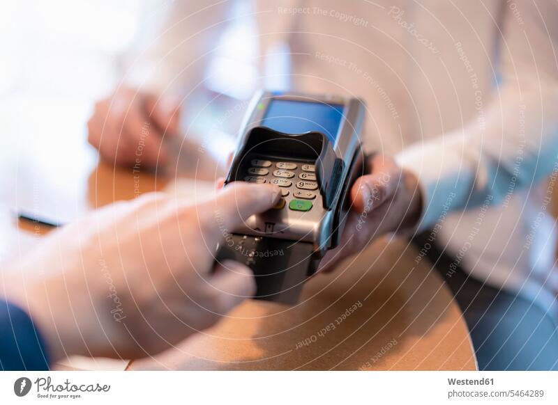 Man using credit card reader, close-up Germany On Part Of partial view cropped Selective focus Differential Focus sales slip voucher Cardkey Reader