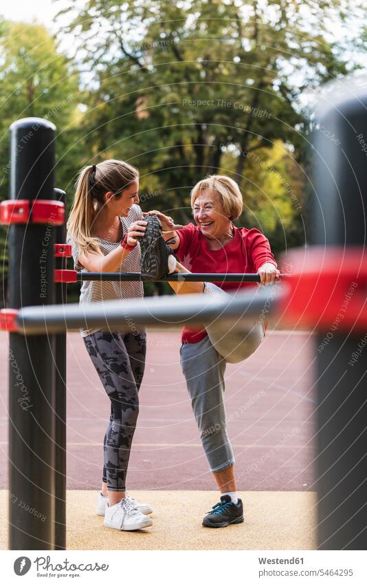 Grandmother and granddaughter training on bars in a park granddaughters Flexibility flexible exercising exercise practising parks Strength strong Force