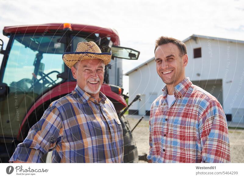 Portrait of two farmers in front of the barn agriculturists portrait portraits agriculture son sons manchild manchildren expertise expert knowledge know-how