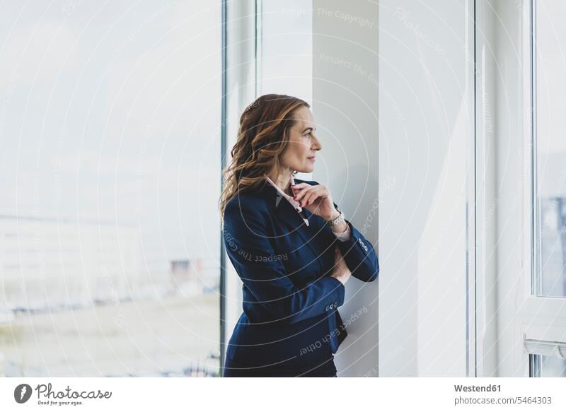 Mature businesswoman looking out of window in office Occupation Work job jobs profession professional occupation business life business world business person