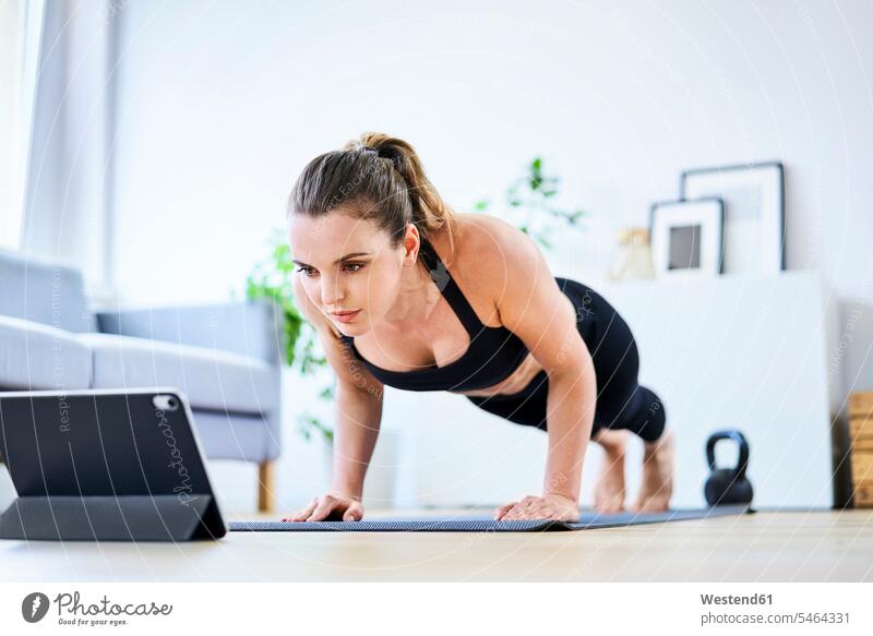 Woman learning exercise on internet through tablet PC at home color image colour image indoors indoor shot indoor shots interior interior view Interiors