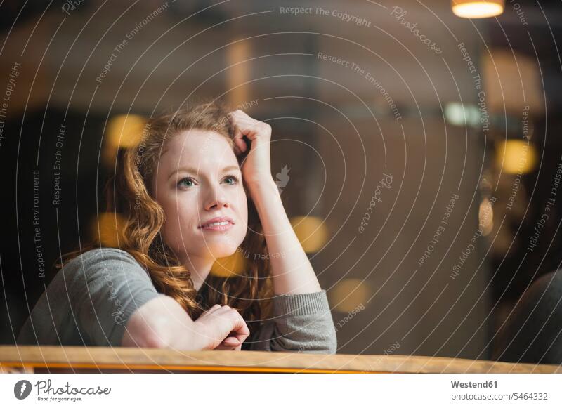 Thoughtful woman leaning on table seen through glass window in coffee shop color image colour image outdoors location shots outdoor shot outdoor shots day