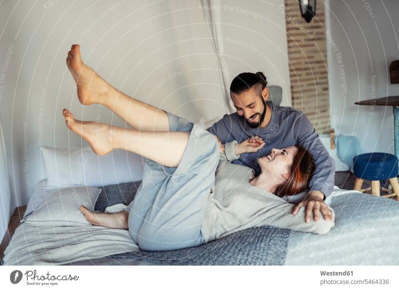 Couple having fun on bed in bedroom at home color image colour image indoors indoor shot indoor shots interior interior view Interiors day daylight shot