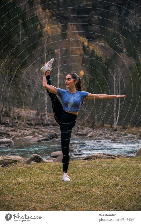 Young flexible woman doing stretching exercise against river, Ordesa National Park, Huesca, Spain color image colour image outdoors location shots outdoor shot