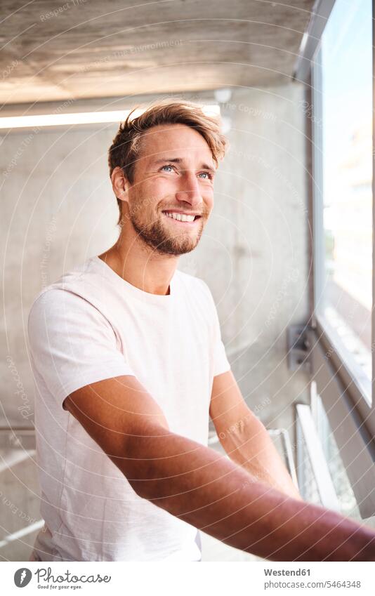 Portrait of smiling young man wearing white t-shirt looking out of window human human being human beings humans person persons caucasian appearance