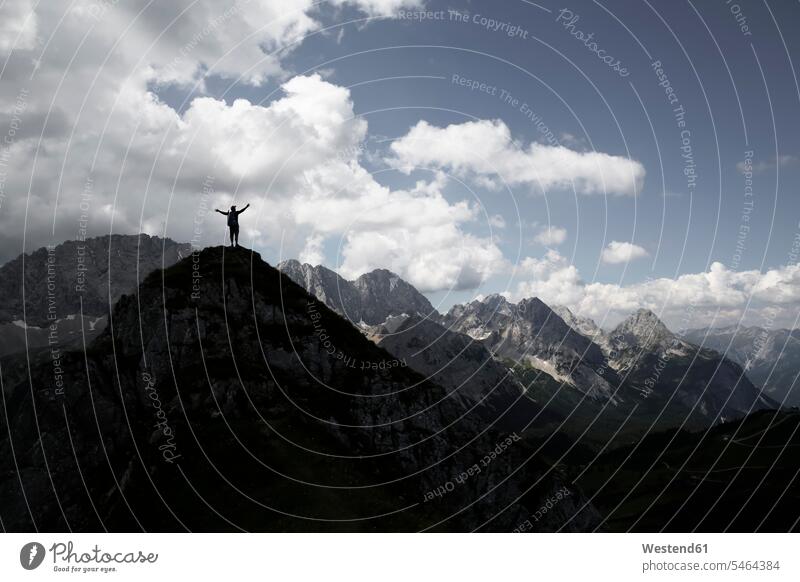 Austria, Tyrol, silhouette of man cheering on mountain peak mountains silhouettes jubilation summit mountaintops summits mountain top men males mountainscape