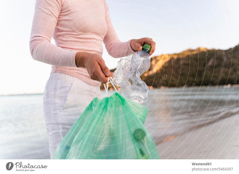Woman collecting empty plastic bottles on the beach human human being human beings humans person persons caucasian appearance caucasian ethnicity european 1