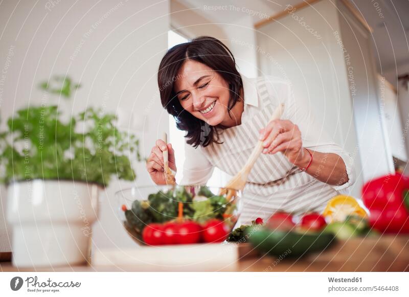 Mature woman preparing salad in her kitchen human human being human beings humans person persons caucasian appearance caucasian ethnicity european adult