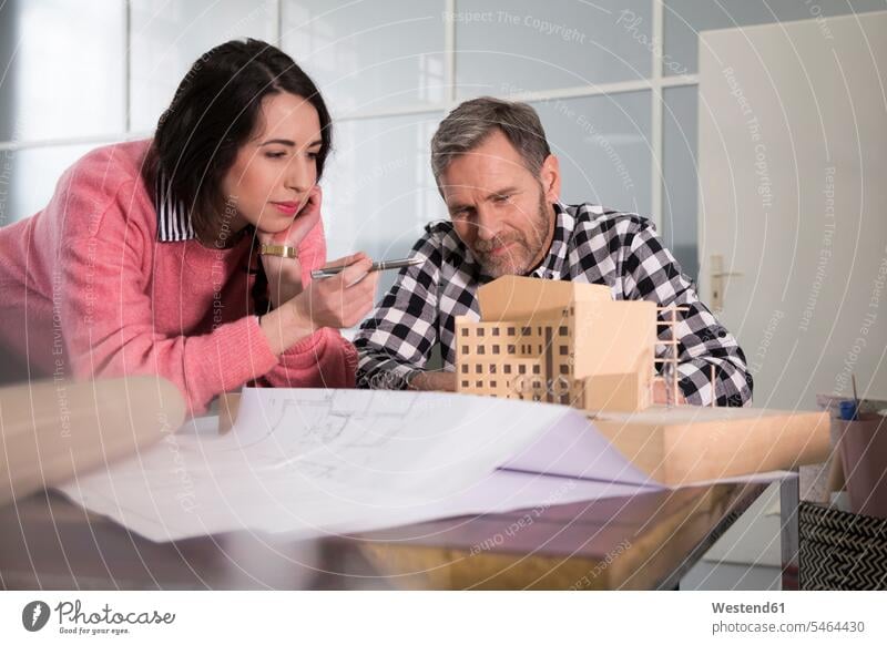 Colleagues examining architectural model in office Architectural Model scrutiny scrutinizing colleagues architects offices office room office rooms models