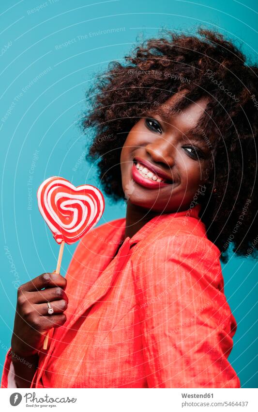 Portrait of beautiful young woman holding lollipop in studio human human being human beings humans person persons African black black ethnicity coloured