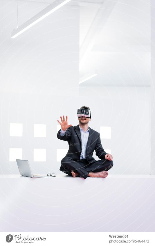 Businessman wearing VR glasses in office next to laptop Occupation Work job jobs profession professional occupation business life business world business person
