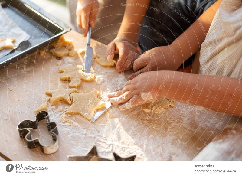 Crop view of children cutting out cookies Tables wood wood table knives bake shapes star Star Shaped Star Shapes star-shaped stars at home free time