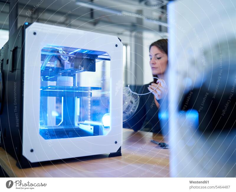 Woman and 3D printer on table human human being human beings humans person persons caucasian appearance caucasian ethnicity european 1 one person only