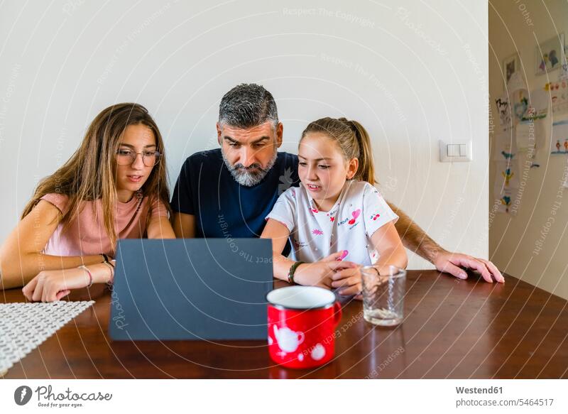Father with two daughters looking at tablet on wooden table at home cup mugs Drinking Glass Drinking Glasses T- Shirt t-shirts tee-shirt Tables wood table video