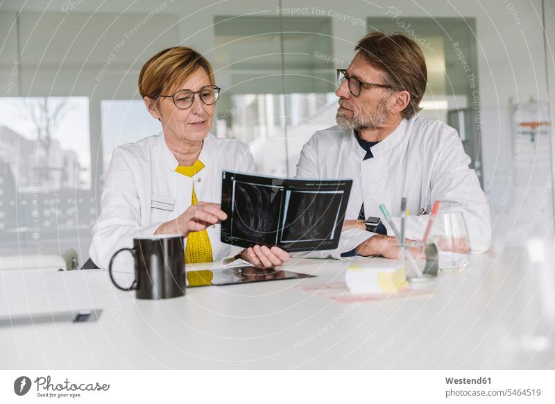 Two doctors discussing x-ray image of a hand Occupation Work job jobs profession professional occupation images picture pictures radiographies radiography