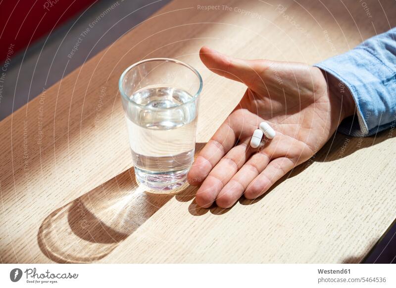 Hand with pills and water glass human human being human beings humans person persons caucasian appearance caucasian ethnicity european 1 one person only