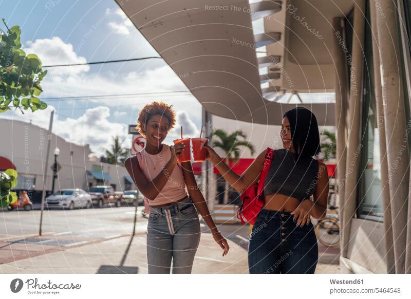 USA, Florida, Miami Beach, two happy female friends having a soft drink in the city refreshing drink soft drinks refreshing drinks happiness town cities towns