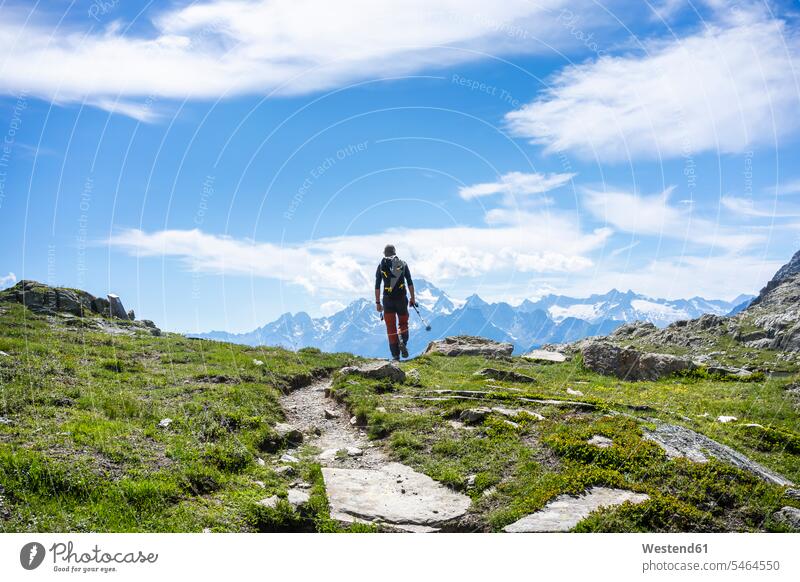 Man hiking on mountain path at Western Rhaetian Alps, Sondrio, Italy color image colour image outdoors location shots outdoor shot outdoor shots day