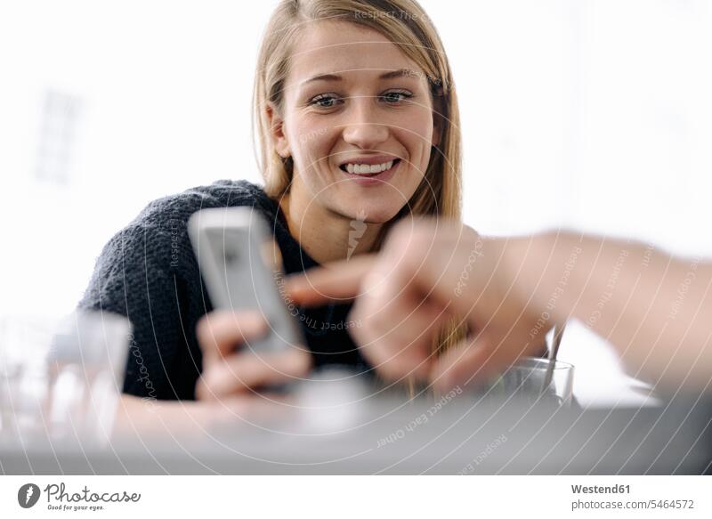 Portrait of smiling young woman and finger pointing on smartphone human human being human beings humans person persons caucasian appearance caucasian ethnicity