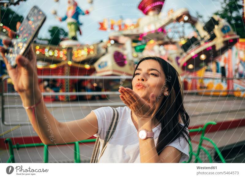Young woman blowing kiss while taking selfie at amusement park color image colour image Ukraine leisure activity leisure activities free time leisure time