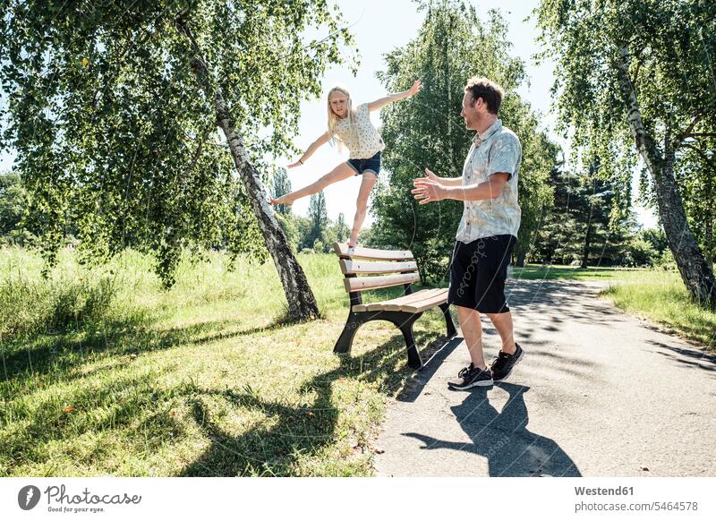 Father watching daughter balancing on a bench in park human human being human beings humans person persons caucasian appearance caucasian ethnicity european
