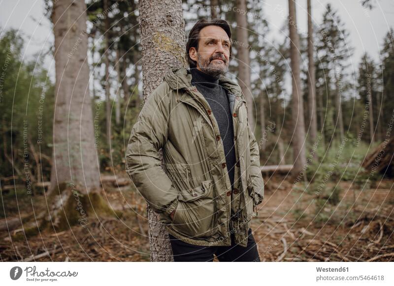 Mature hiker in the forest coat coats jackets smile delight enjoyment Pleasant pleasure happy contemplative pensively Reflective thoughtful content