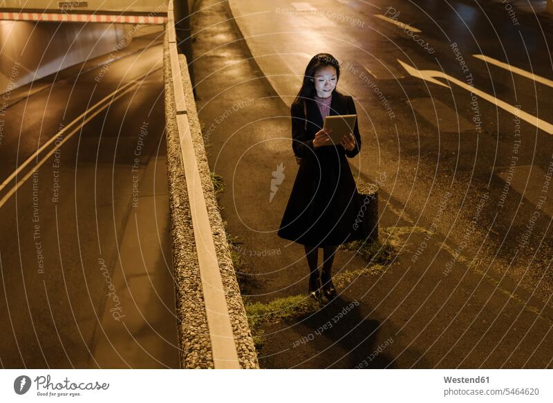 Young woman using tablet in the city at night, Frankfurt, Germany business life business world business person businesspeople business woman business women