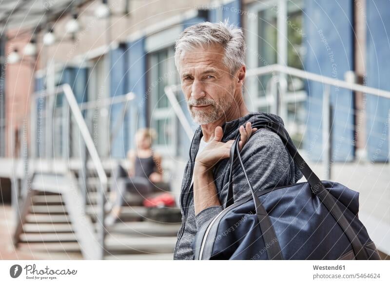 Portrait of mature man with sports bag in front of gym men males portrait portraits gyms Health Club Gym Bag Adults grown-ups grownups adult people persons