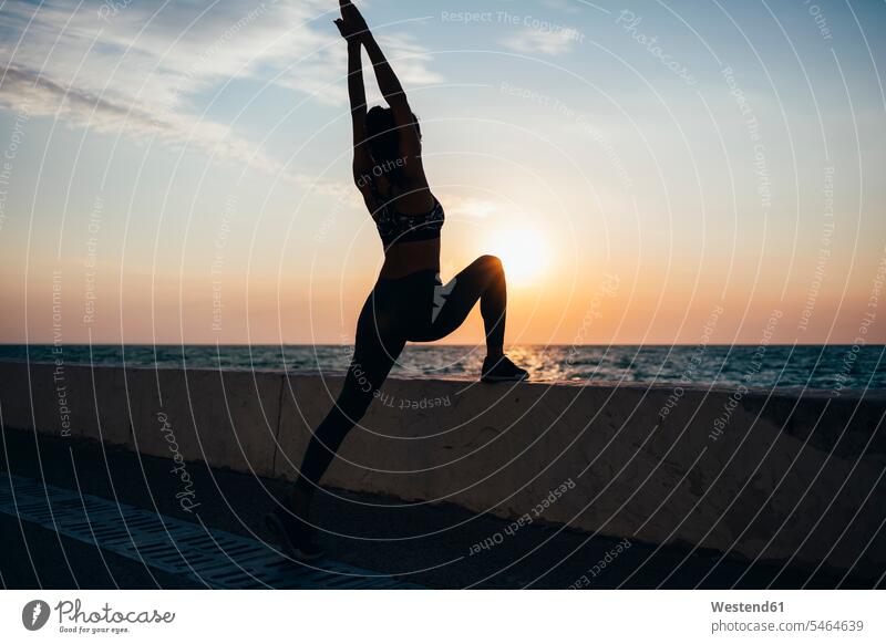 Silhouette woman practicing yoga at promenade during sunrise outdoors location shots outdoor shot outdoor shots color image colour image Self Improvement