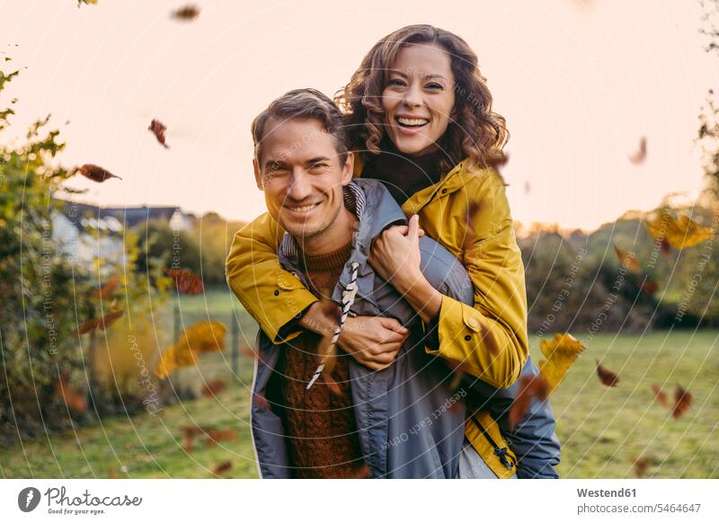 Portrait of man carrying woman piggyback outdoors in autumn human human being human beings humans person persons caucasian appearance caucasian ethnicity
