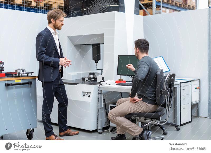 Two men talking at machine in modern factory man males factories contemporary speaking Adults grown-ups grownups adult people persons human being humans