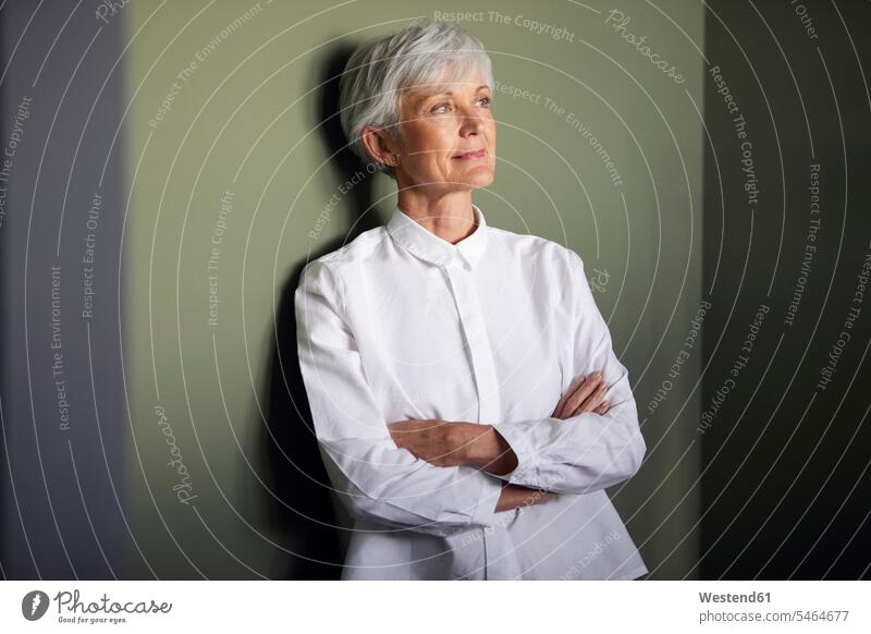 Portrait of senior businesswoman leaning against wall looking at distance human human being human beings humans person persons caucasian appearance