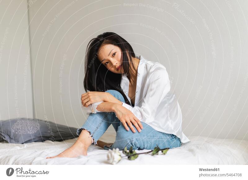 Portrait of attractive young woman sitting on bed with white rose beautiful pretty good-looking Attractiveness Handsome beds portrait portraits Seated Rose
