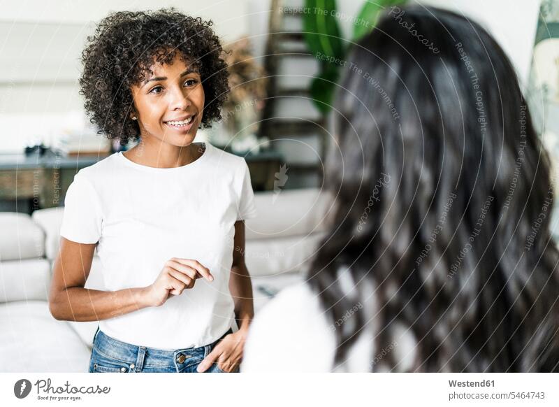 Portrait of smiling woman talking to a friend at home females women female friends speaking portrait portraits Adults grown-ups grownups adult people persons