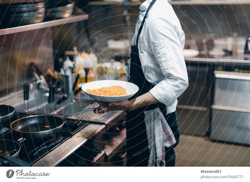 Chef cooking pasta in Italian restaurant kitchen Occupation Work job jobs profession professional occupation Chefs cooks dish dishes Plates devices Cookers