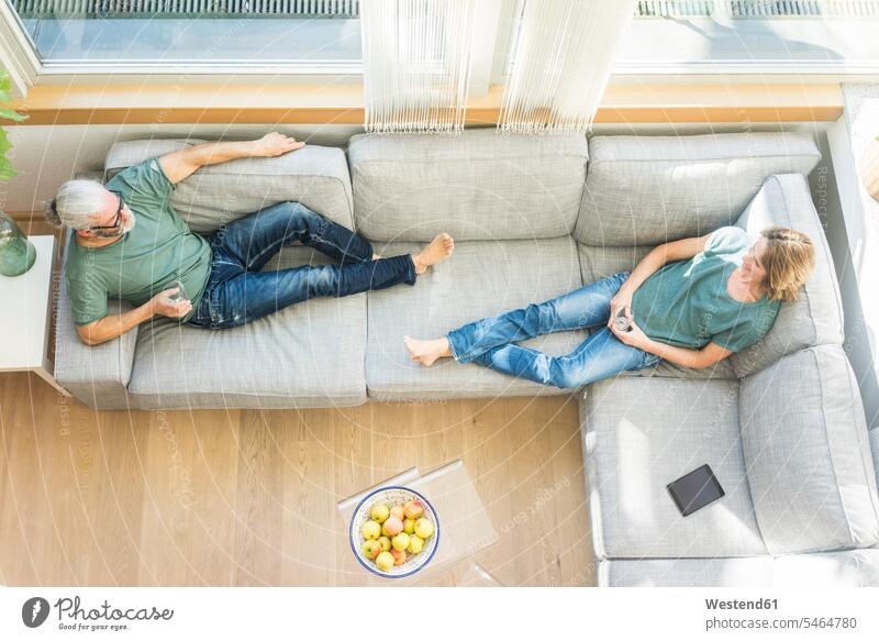 Mature couple relaxing on couch at home relaxed relaxation twosomes partnership couples settee sofa sofas couches settees people persons human being humans